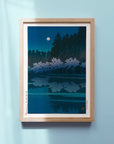 Framed Japanese Art Poster by Kawase Hasui featuring a moonlit lake and Cherry Blossom under a night sky.