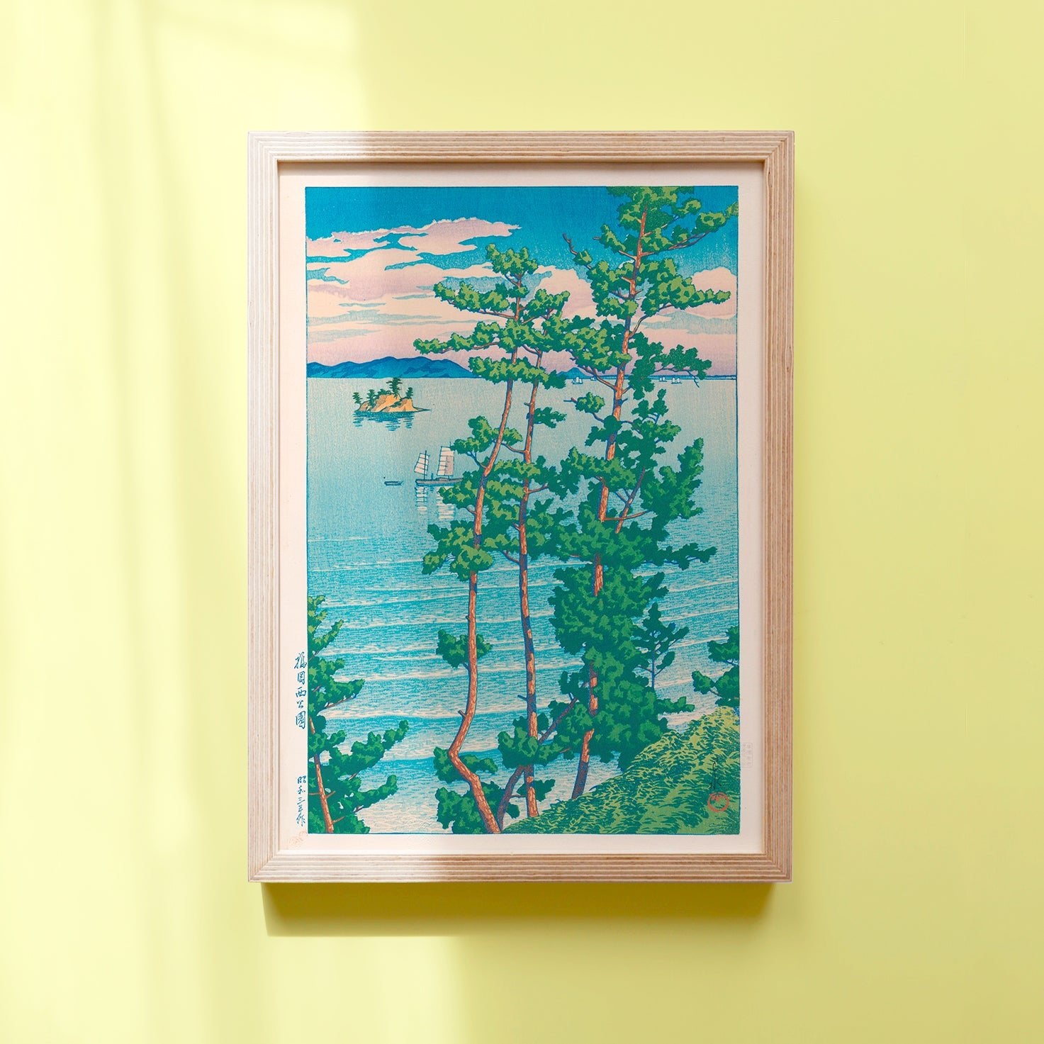 Framed Japanese art poster by Hasui Kawase depicting a boat on the water, pine trees, and white waves lapping on the beach.