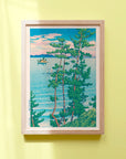 Framed Japanese art poster by Hasui Kawase depicting a boat on the water, pine trees, and white waves lapping on the beach.