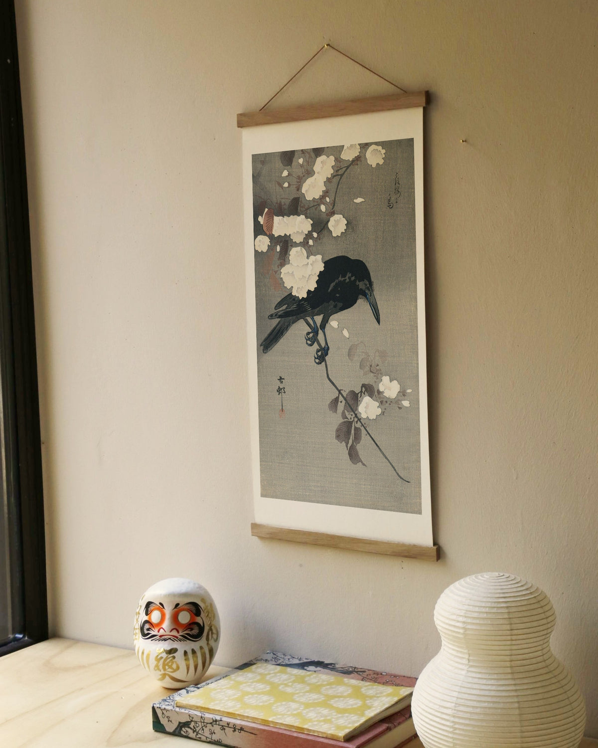 Crow on a cherry branch – Ohara Koson art print 30 x 60 cm on a wooden poster hanger in an interior