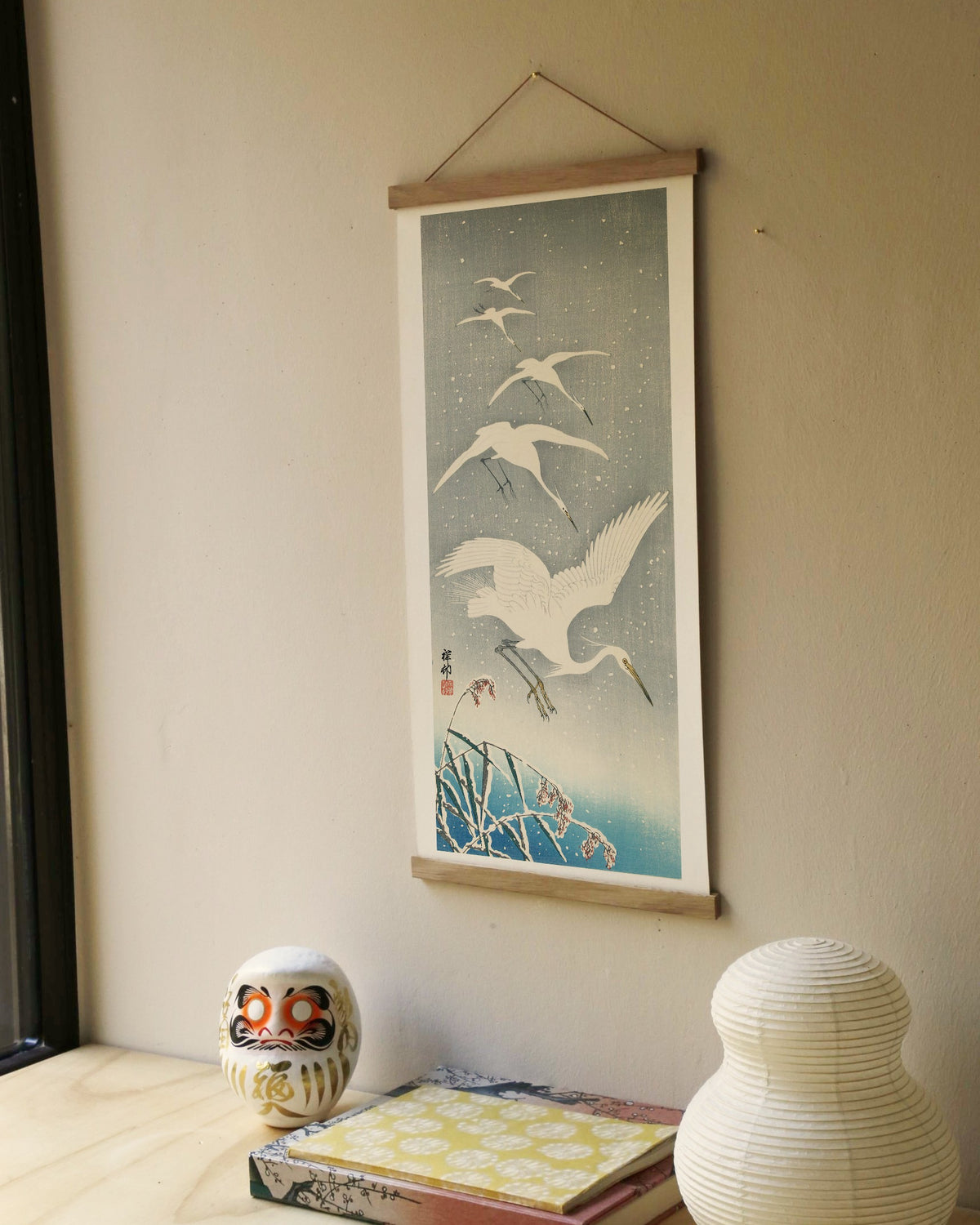 Descending egrets in snow – Ohara Koson art print 30 x 60 cm on a wooden poster hanger in an interior