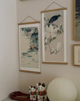 Myna on Magnolia Branch – Ohara Koson art print 30 x 60 cm on a wooden poster hanger in an interior