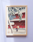 Framed Japanese Art Poster by Kawase Hasui, depicting a woman walking in the snowstorm with an umbrella.