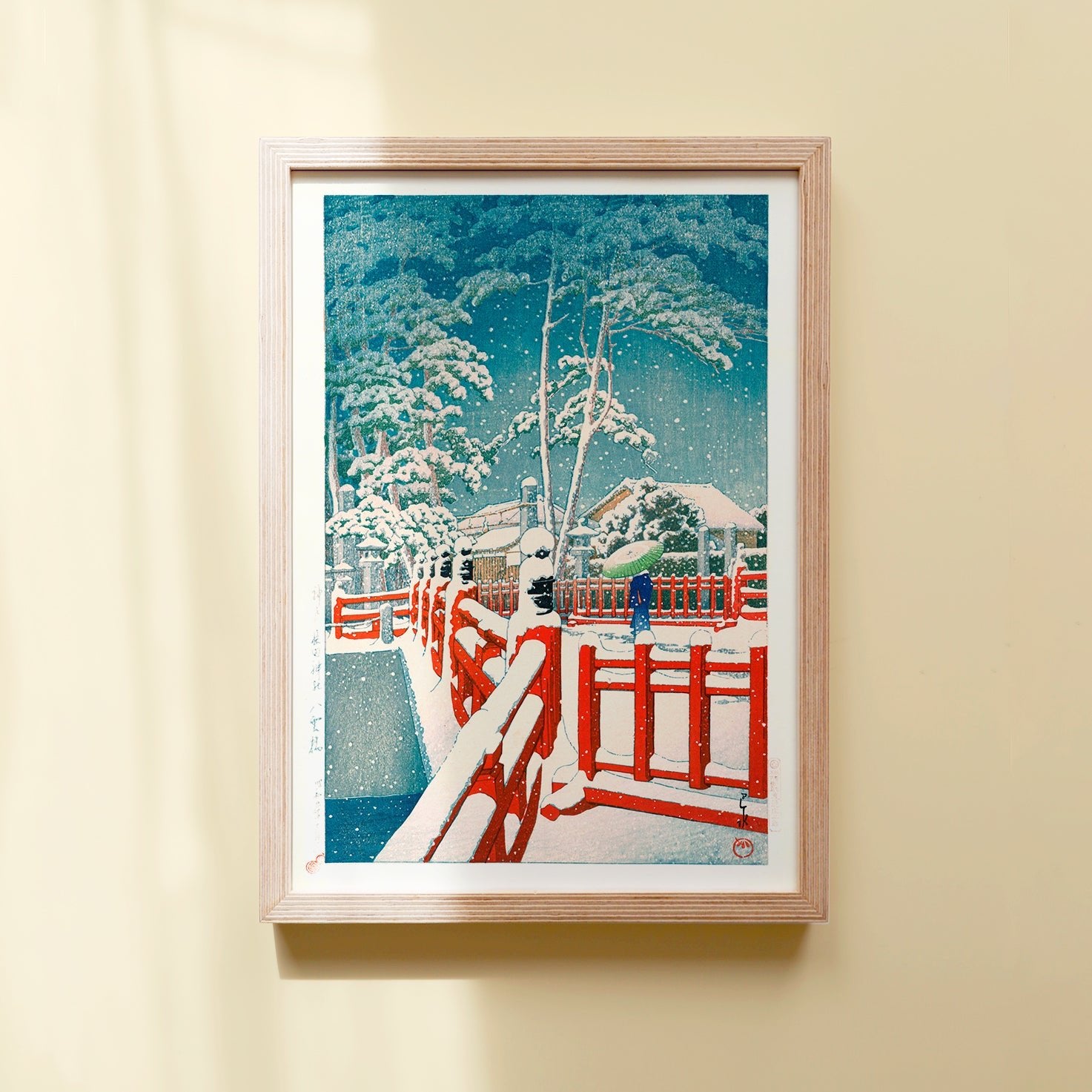 Framed Japanese Art Poster by Kawase Hasui featuring a woman with an umbrella crossing a red bridge in the snow